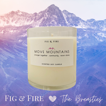 Load image into Gallery viewer, Image of the Move Mountains clear glass candle for The Breasties. Background image has different shades of lavender purple mountains. Image says &quot;Fig &amp; Fire heart The Breasties.&quot;