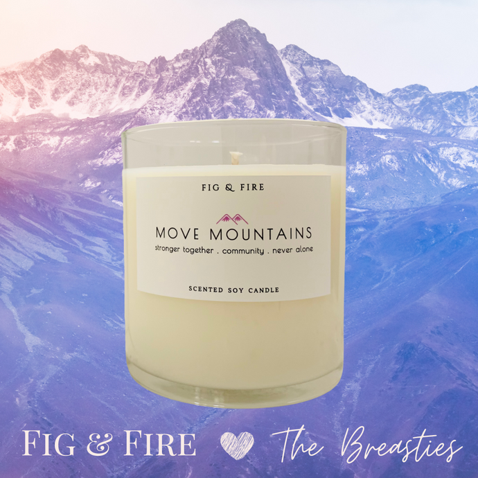 Image of the Move Mountains clear glass candle for The Breasties. Background image has different shades of lavender purple mountains. Image says 