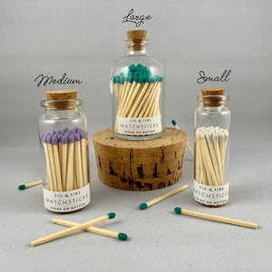Three size glass containers with corks are pictured. Small, medium, and large size color-tip matches.