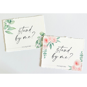 Handcrafted watercolor gift card that says "stand by me?" for a wedding party gift, bridesmaid proposal gift, gift box. Two styles are pictured: one with green leaves and one with pink florals.