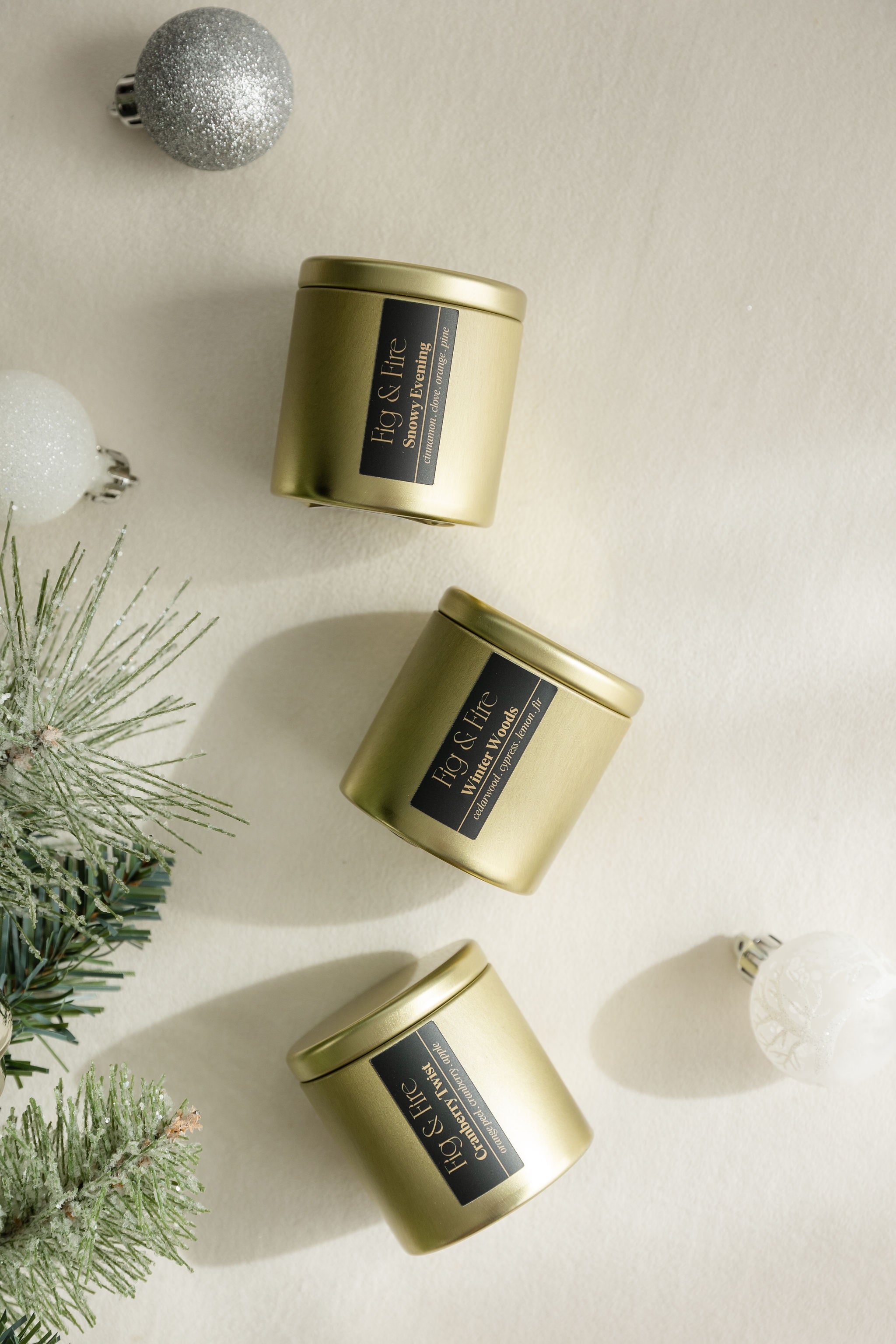 3 gold tin candles - The entire winter collection is featured, with a burn time of 24+ hours each: Cranberry Twist, Snowy Evening, and Winter Woods - non-toxic, all-natural, cruelty-free, vegan, soy candles made with essential oils