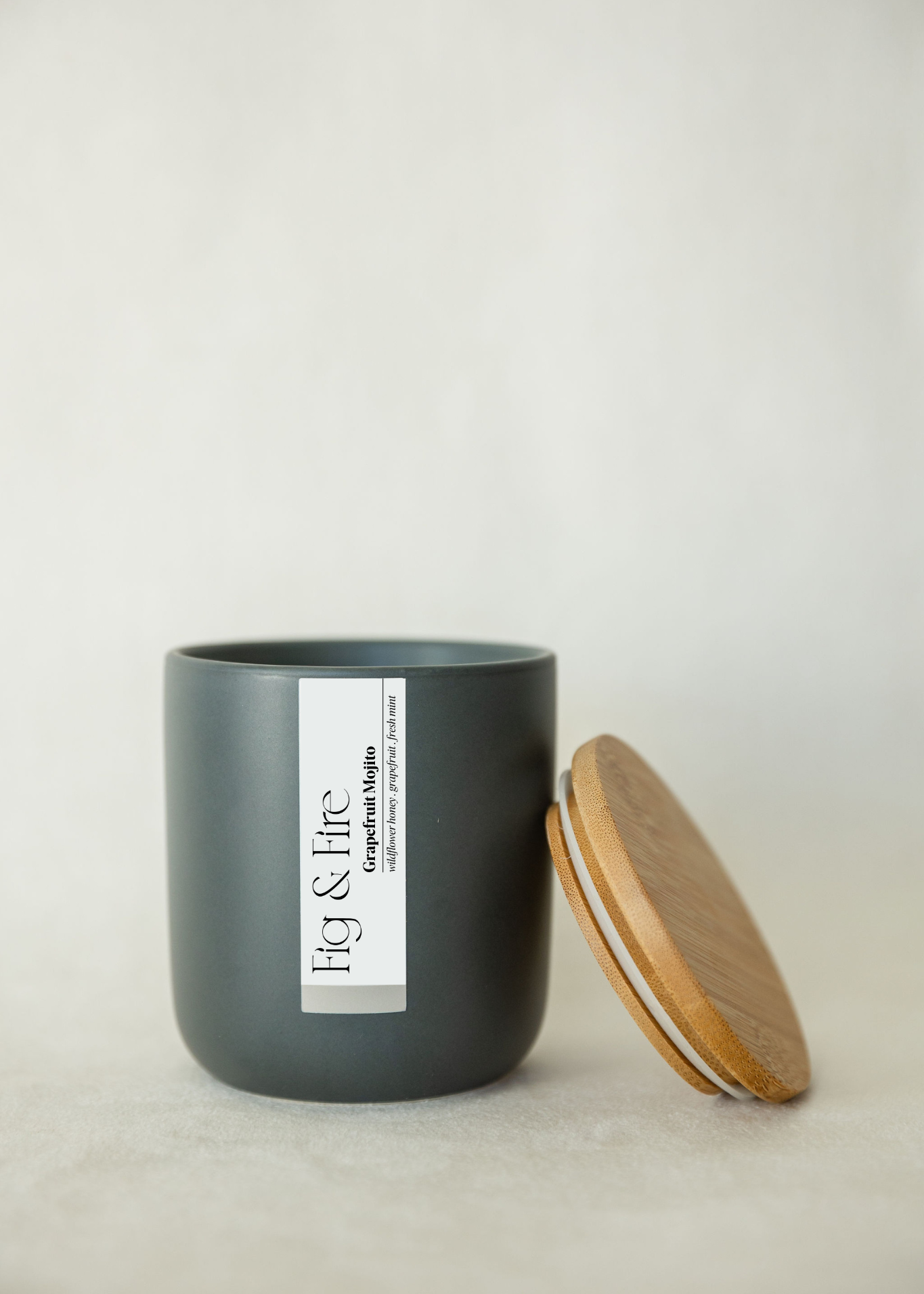 Handcrafted candle - scent is Grapefruit Mojito - scent notes are wildflower honey, pink grapefruit, and fresh mint - all natural soy candle - vegan, non-toxic, made with essential oils - container is a charcoal ceramic tumbler