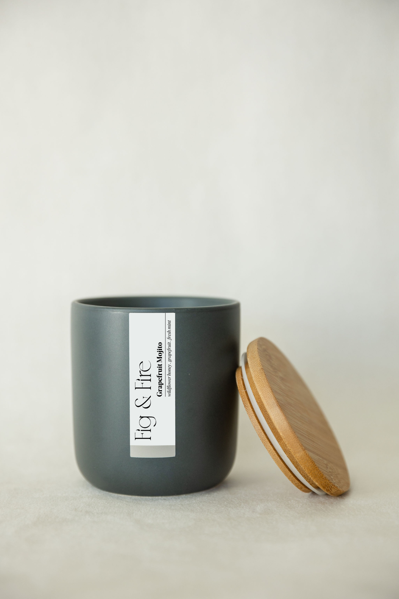 Handcrafted candle - scent is Grapefruit Mojito - scent notes are wildflower honey, pink grapefruit, and fresh mint - all natural soy candle - vegan, non-toxic, made with essential oils - container is a charcoal ceramic tumbler