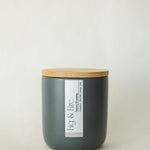 Handcrafted winter candle - scent is snowy evening - smells of clove, pine, orange, and cinnamon - all natural soy candle - vegan, non-toxic, made with essential oils - seasonal collection - container is a charcoal ceramic tumbler with a light brown bamboo wooden lid