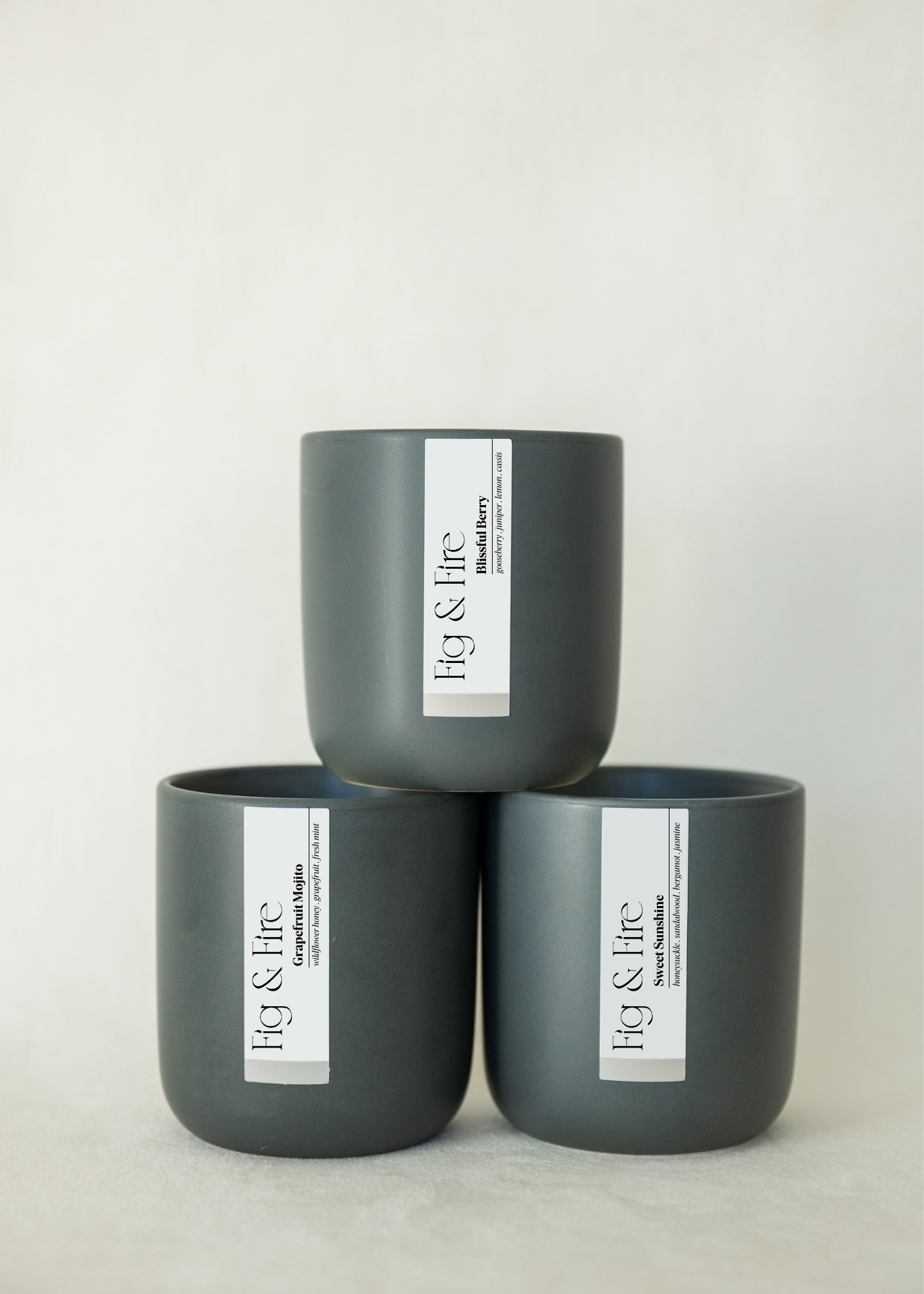 The entire spring collection is featured - Blissful Berry, Grapefruit Mojito, and Sweet Sunshine - the vessels are charcoal ceramic tumblers - all-natural, vegan, soy candles made with essential oils