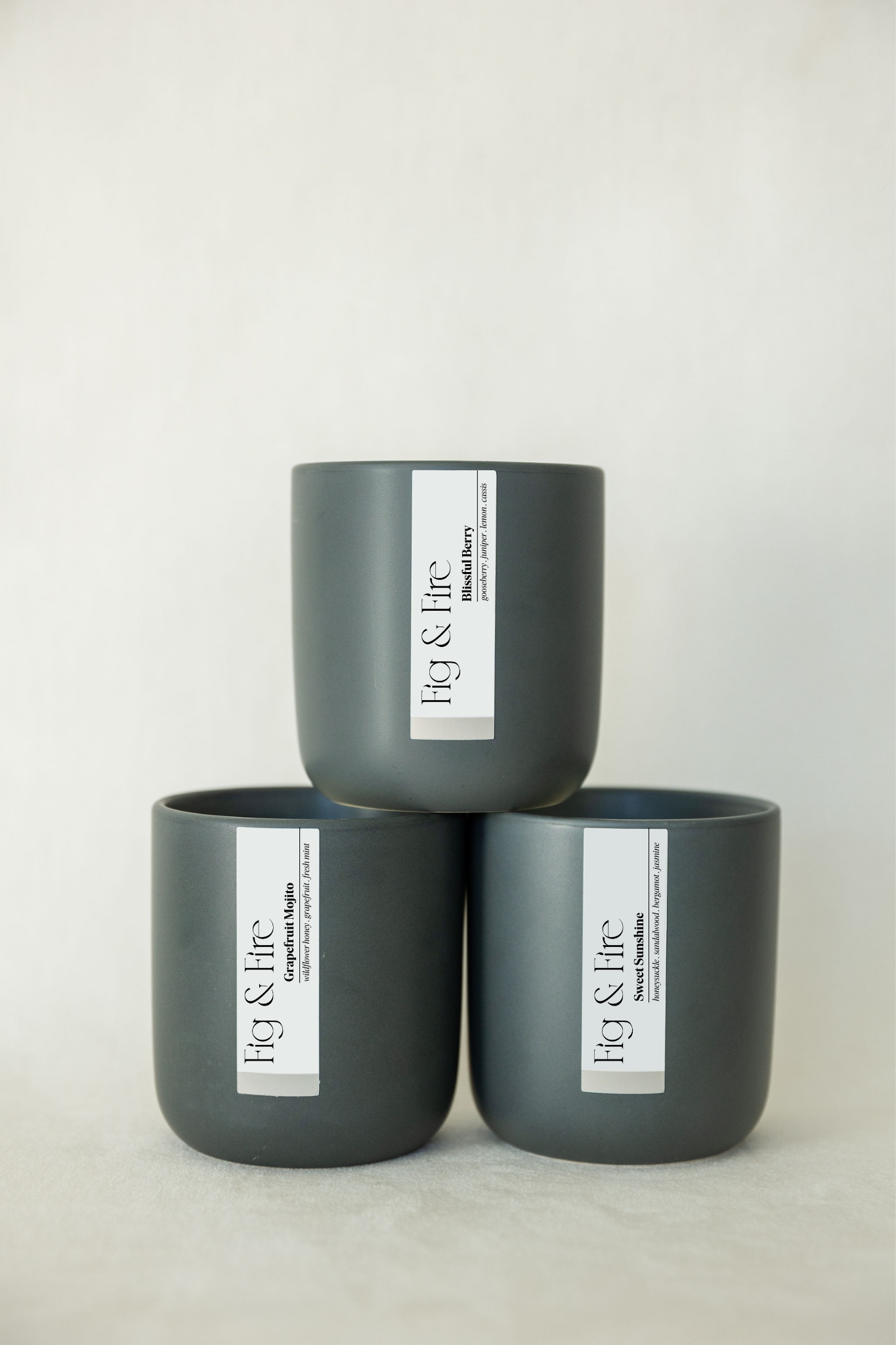 The entire spring collection is featured - Blissful Berry, Grapefruit Mojito, and Sweet Sunshine - the vessels are charcoal ceramic tumblers - all-natural, vegan, soy candles made with essential oils