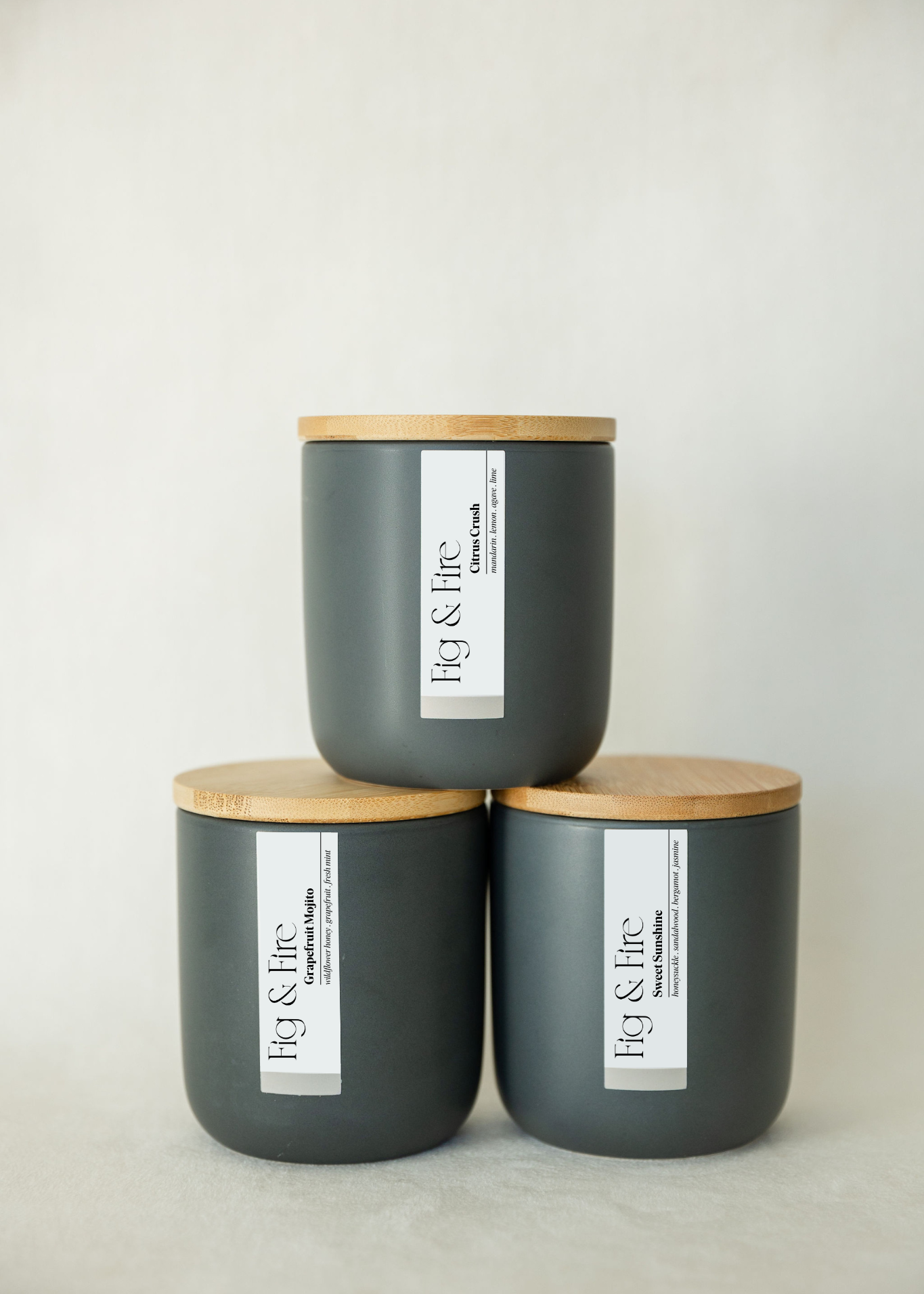 The entire spring collection is featured - Citrus Crush, Grapefruit Mojito, Sweet Sunshine - the vessels are charcoal ceramic tumblers with bamboo wooden lids - all-natural, vegan, non-toxic soy candles made with essential oils
