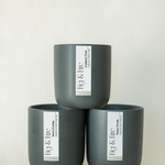 The entire winter collection is featured - Cranberry Twist, Snowy Evening, and Winter Woods - the vessels are charcoal ceramic tumblers - all-natural, vegan, soy candles made with essential oils
