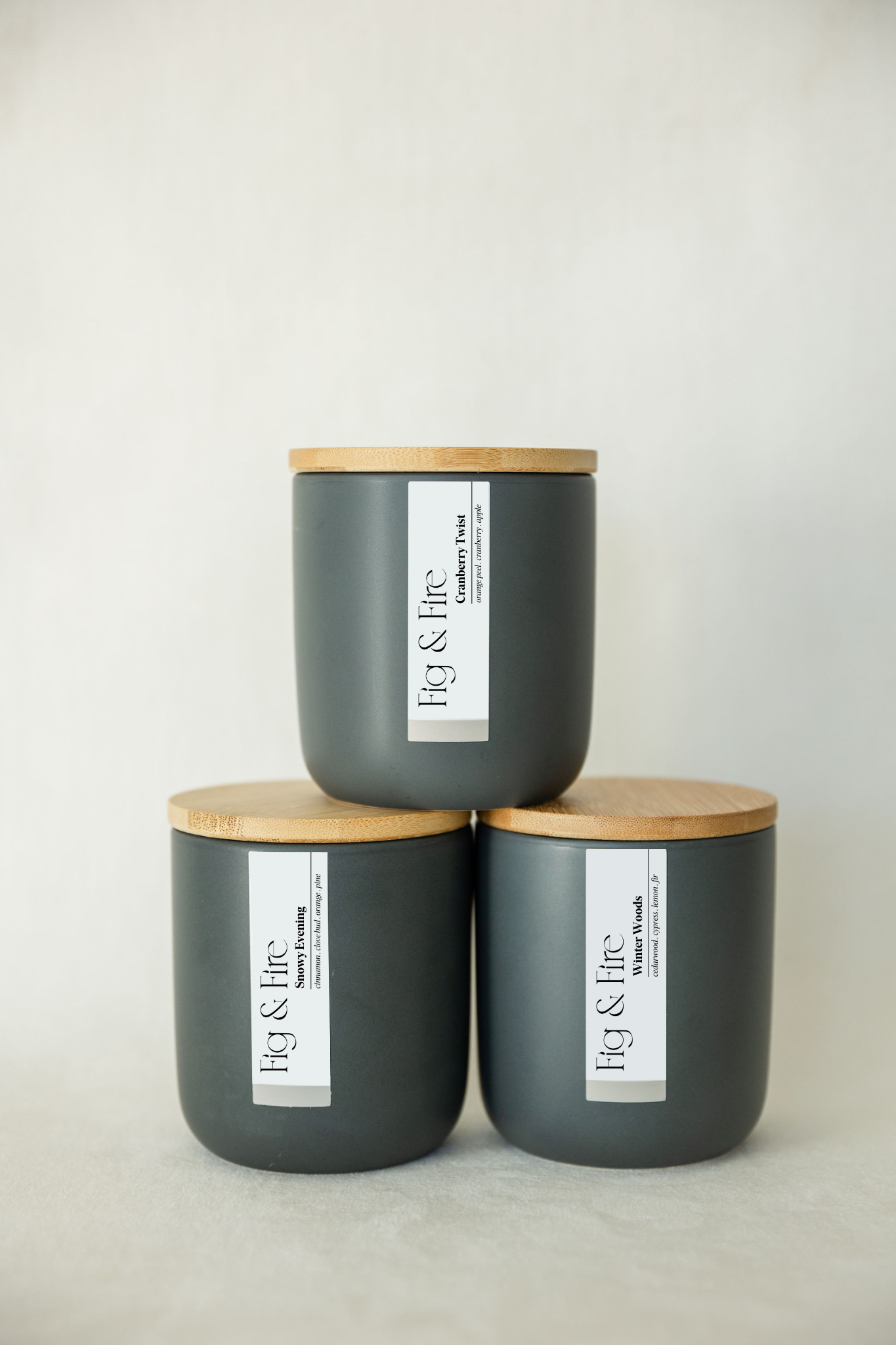 The entire winter collection is featured - Cranberry Twist, Snowy Evening, and Winter Woods - the vessels are charcoal ceramic tumblers with bamboo wooden lids - all-natural, vegan, soy candles made with essential oils