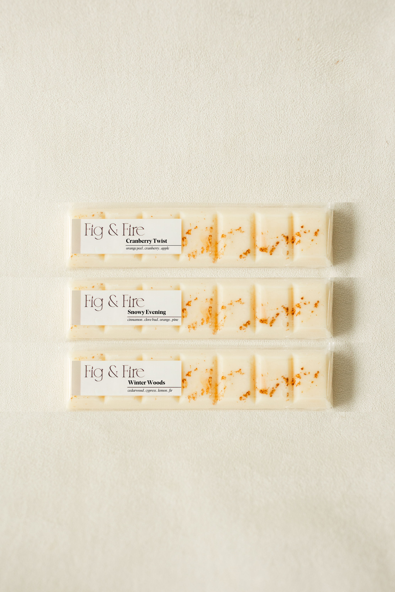 The entire winter collection is featured - Cranberry Twist, Snowy Evening, and Winter Woods - all-natural, vegan, soy wax melts made with essential oils