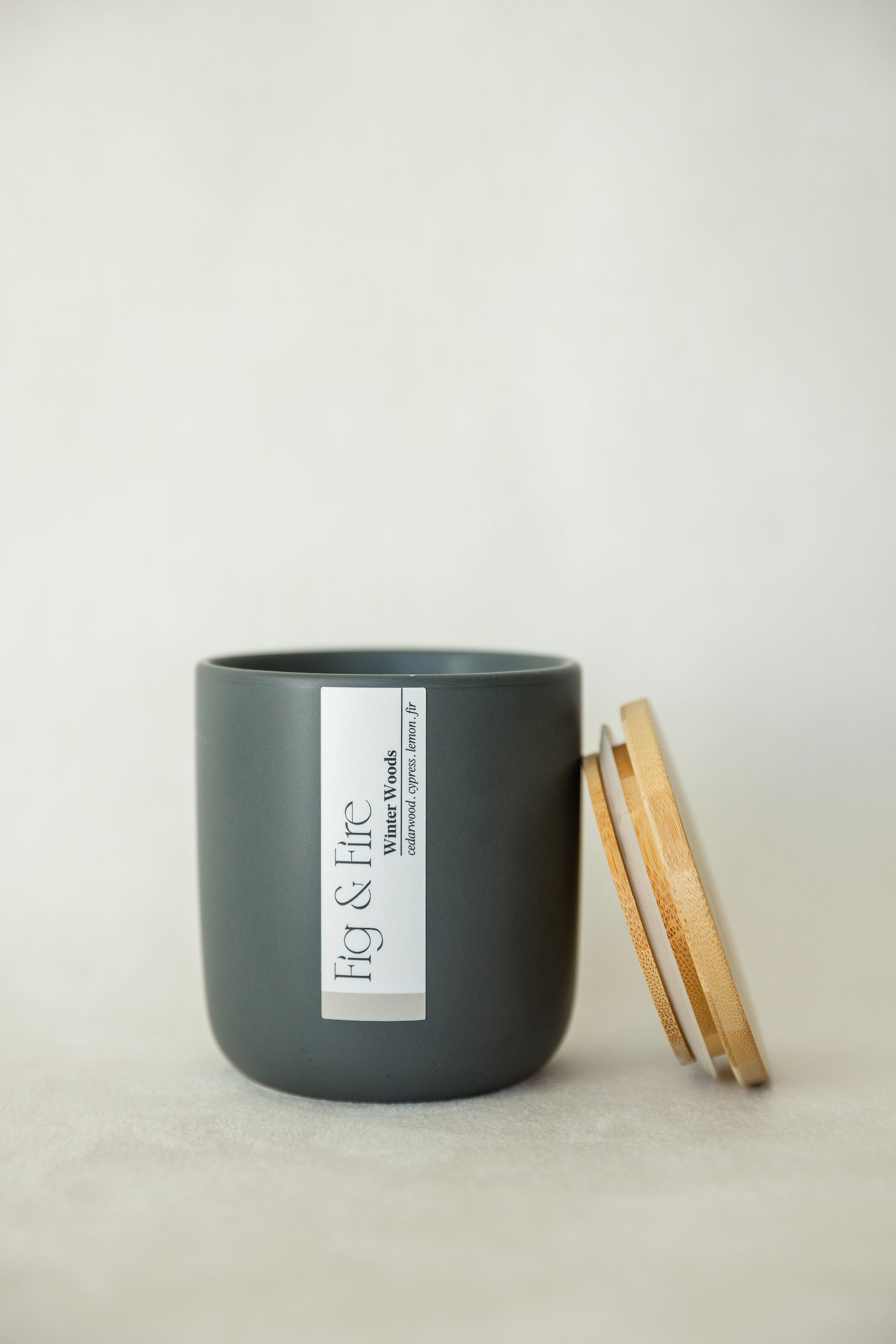 Handcrafted winter candle - scent is winter woods - smells of cypress, fir, evergreen, cedar, and lemon - all natural soy candle - vegan, non-toxic, made with essential oils - seasonal collection - container is a charcoal ceramic tumbler