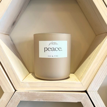 Load image into Gallery viewer, Handcrafted candle - gorgeous neutral colored glass candle with the word “peace” on it. Scent is Peace - smells of lemon verbena, oakmoss, sage, tonka bean, and amber - all natural soy candle - vegan, non-toxic, made with essential oils - container is a 2-wick glass vessel