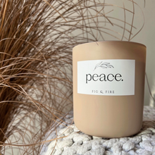 Load image into Gallery viewer, Handcrafted candle - gorgeous neutral colored glass candle with the word “peace” on it. Scent is Peace - smells of lemon verbena, oakmoss, sage, tonka bean, and amber - all natural soy candle - vegan, non-toxic, made with essential oils - container is a 2-wick glass vessel