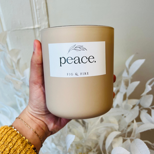 Handcrafted candle - gorgeous neutral colored glass candle with the word “peace” on it. Scent is Peace - smells of lemon verbena, oakmoss, sage, tonka bean, and amber - all natural soy candle - vegan, non-toxic, made with essential oils - container is a 2-wick glass vessel