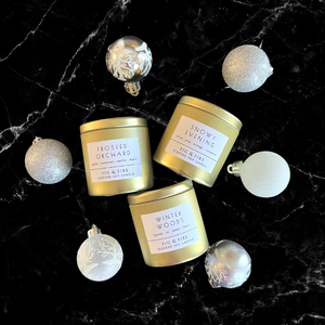 3 gold tin candles - The entire winter collection is featured as silver tins, with a burn time of 25+ hours each- Frosted Orchard, Snowy Evening, and Winter Woods - non-toxic, all-natural, cruelty-free, vegan, soy candles made with essential oils
