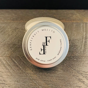 Handcrafted candle - scent is Grapefruit Mojito - smells of pink citrus, fresh mint, and wildflower honey - all natural soy candle - vegan, non-toxic, made with essential oils - container is a silver tin
