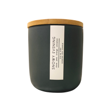 Load image into Gallery viewer, Handcrafted winter candle - scent is snowy evening - smells of clove, pine, orange, and cinnamon - all natural soy candle - vegan, non-toxic, made with essential oils - seasonal collection - container is a charcoal ceramic tumbler with a light brown bamboo wooden lid