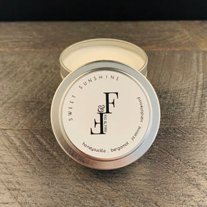 Handcrafted candle - scent is Sweet Sunshine - smells of honeysuckle, bergamot, jasmine, and sandalwood - all natural soy candle - vegan, non-toxic, made with essential oils - container is a silver tin