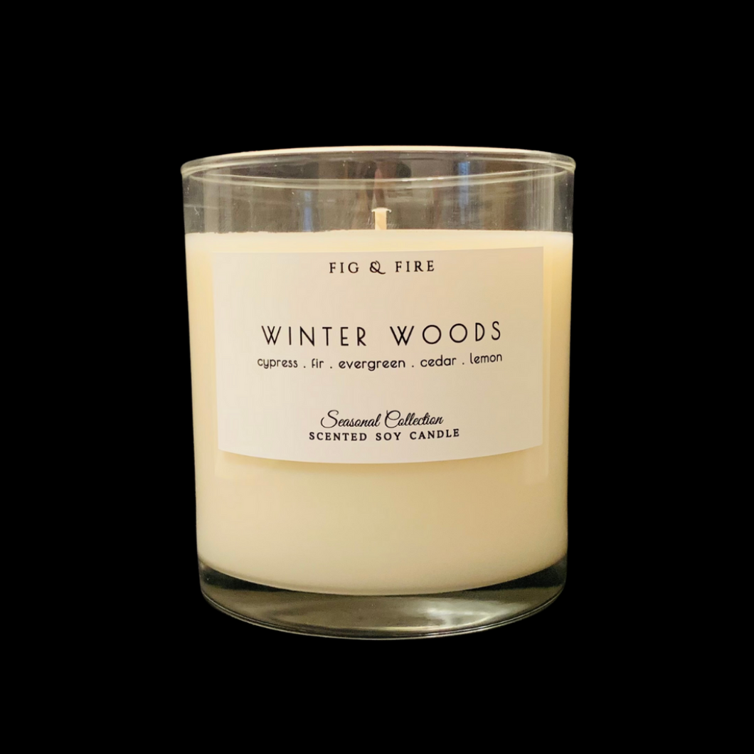 Handcrafted winter candle - scent is winter woods - smells of cypress, fir, evergreen, cedar, and lemon - all natural soy candle - vegan, non-toxic, made with essential oils - seasonal collection - container is a clear glass tumbler