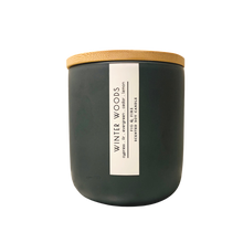 Load image into Gallery viewer, Handcrafted winter candle - scent is winter woods - smells of cypress, fir, evergreen, cedar, and lemon - all natural soy candle - vegan, non-toxic, made with essential oils - seasonal collection - container is a charcoal ceramic tumbler with a light brown bamboo wooden lid