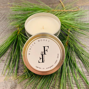 Handcrafted winter candle - scent is winter woods - smells of cypress, fir, evergreen, cedar, and lemon - all natural soy candle - vegan, non-toxic, made with essential oils - container is a silver tin - seasonal collection
