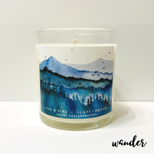 Load image into Gallery viewer, Clear glass candle with original artwork: blue and green mountains with trees and birds.
